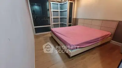 Spacious bedroom with large windows offering stunning city views, featuring a comfortable bed and modern decor.