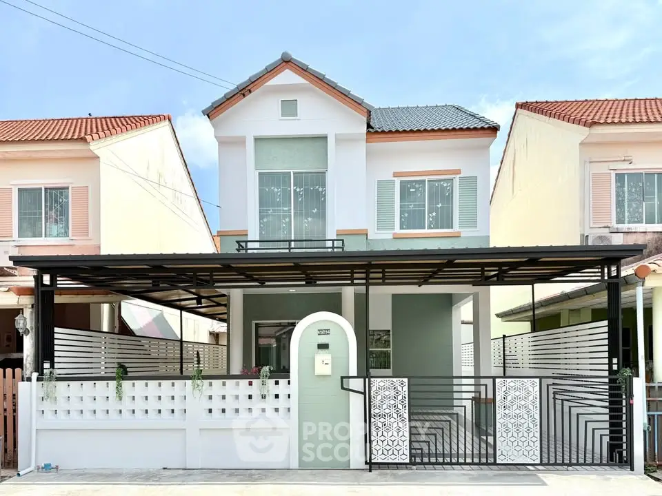 Charming two-story house with modern facade and gated entrance in a serene neighborhood.