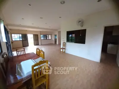 Spacious open-plan living area with dining table and ample natural light.