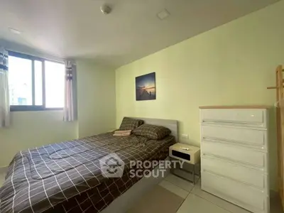Cozy bedroom with natural light and modern furnishings in a serene apartment setting.