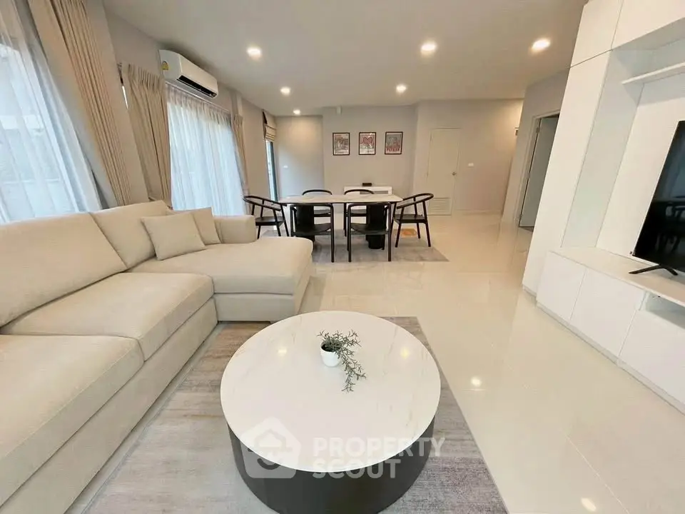 Spacious modern living room with elegant decor and ample natural light, perfect for relaxation and entertainment.