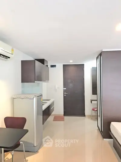 Modern studio apartment with compact kitchen and sleek design, perfect for urban living.