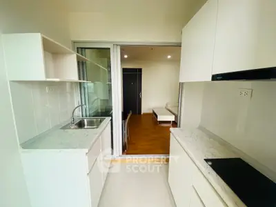 Modern kitchen with sleek white cabinets and marble countertops in open layout apartment.
