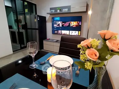 Modern dining area with elegant table setting and wall-mounted TV in a stylish apartment.