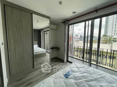Modern bedroom with large mirrored wardrobe and city view balcony