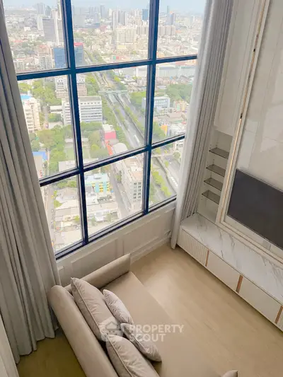 Luxurious high-rise living room with stunning city view through large windows, elegant decor and cozy seating.