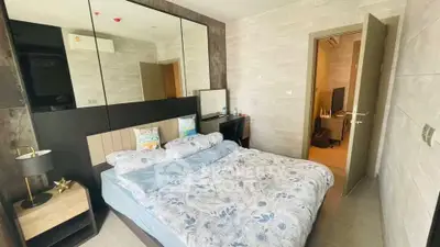 Modern bedroom with stylish decor and mirrored wall in a cozy apartment.