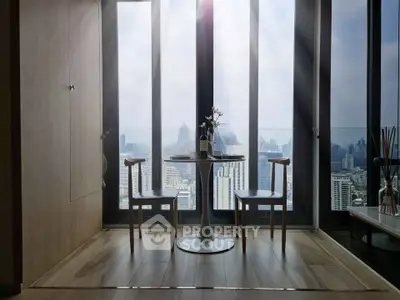 Stunning city view from modern dining area with floor-to-ceiling windows and elegant furniture.