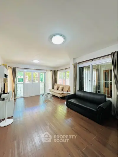 Spacious living room with elegant hardwood floors and large windows for natural light.