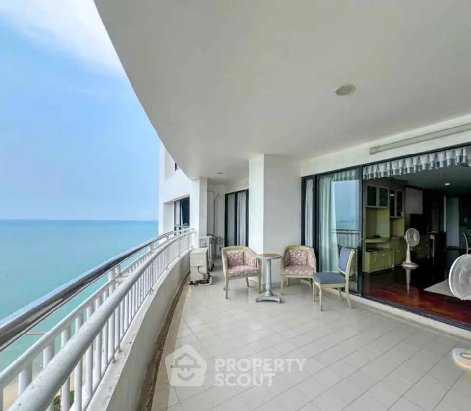 Spacious ocean-view balcony with seating area in modern apartment