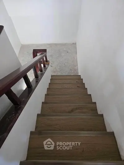 Modern wooden staircase with sleek railing in minimalist home interior