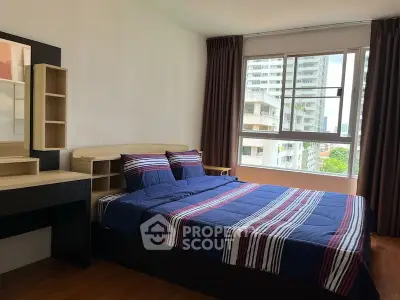Spacious bedroom with large window and modern decor in urban apartment.