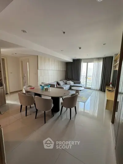 Spacious modern living room with elegant dining area and large windows offering natural light.