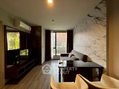 Modern living room with marble accent wall and large window for natural light.