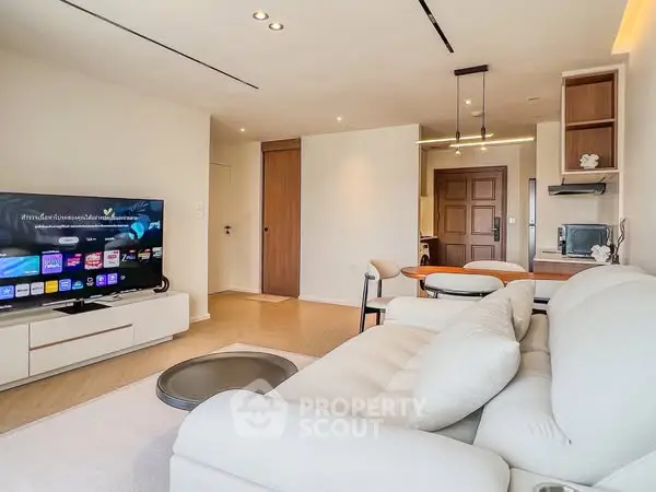 Modern living room with sleek furniture and large TV, perfect for relaxation.