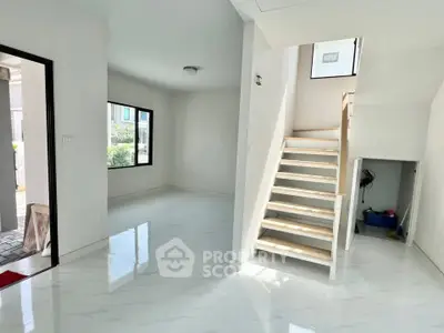 Bright modern interior with sleek staircase and glossy floors, perfect for contemporary living.