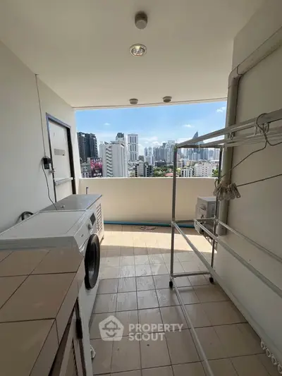 Spacious balcony with laundry area and stunning city skyline view