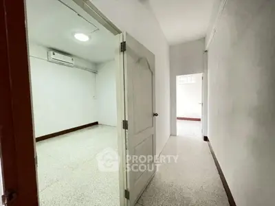 Spacious empty room with white walls and air conditioning, ready for customization.