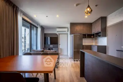 Modern open-plan living room and kitchen with sleek design and natural light