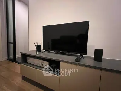 Modern living room with sleek TV setup and stylish console in contemporary apartment.