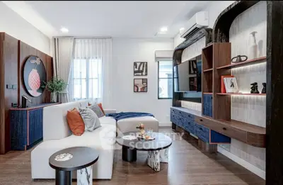 Modern living room with stylish furniture and elegant decor, featuring a cozy seating area and contemporary shelving.