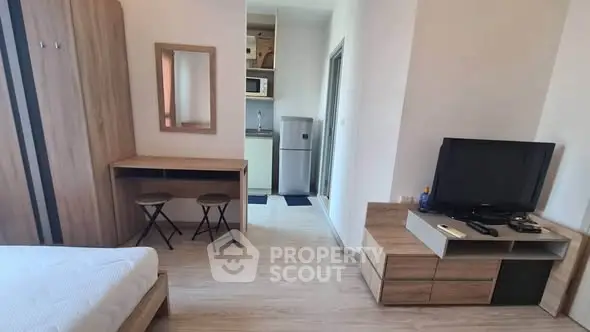 Modern studio apartment with cozy living area and compact kitchen.