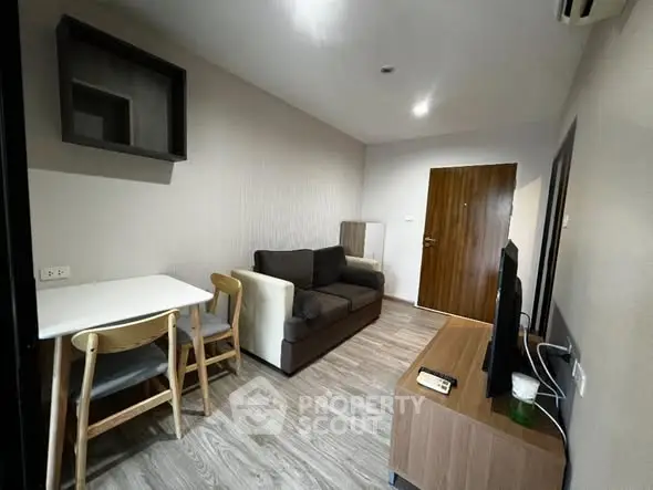 Cozy living room with modern furniture and wooden flooring in a stylish apartment.