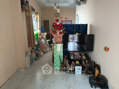 Cozy living room with TV, decorative items, and marble flooring