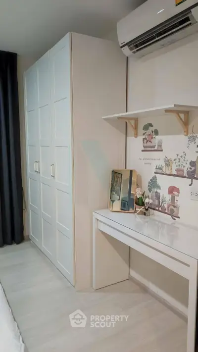 Modern bedroom with sleek wardrobe and stylish desk, featuring air conditioning and elegant decor.
