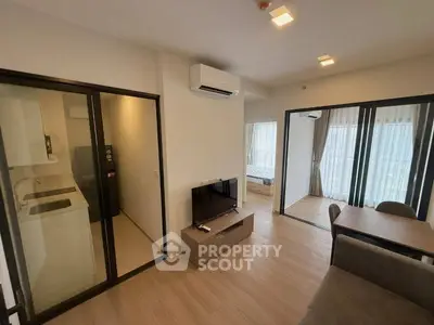 Modern apartment interior with open living area and kitchen, featuring sleek design and natural light.