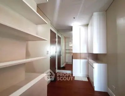 Spacious storage room with modern white cabinetry and wooden flooring