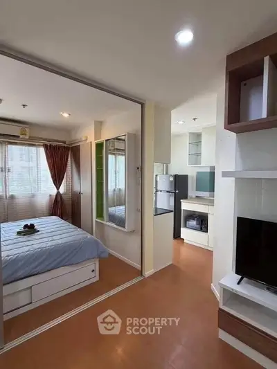 Modern studio apartment with cozy bedroom and open living area, featuring sleek furniture and ample natural light.