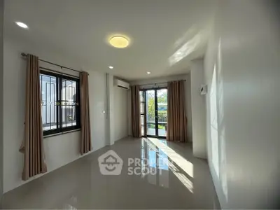 Spacious living room with large windows and natural light, perfect for modern living.