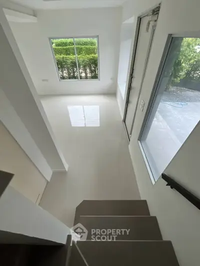 Bright and airy interior with large windows and modern staircase, perfect for contemporary living.