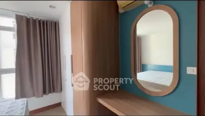 Cozy bedroom with modern wooden wardrobe and stylish oval mirror