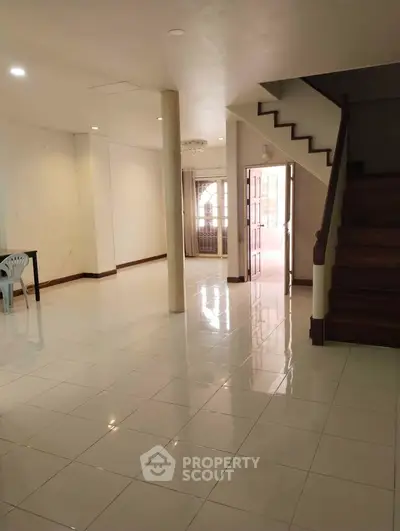 Spacious open-plan living area with staircase and natural light