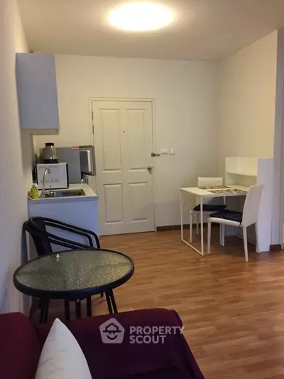 Cozy living room with modern furniture and small dining area, perfect for urban living.