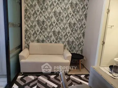 Modern living room with geometric accent wall and cozy sofa