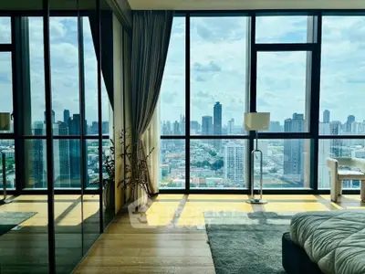 Luxurious bedroom with floor-to-ceiling windows offering stunning city skyline views.