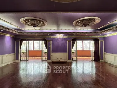 Luxurious purple-themed living room with ornate ceiling and hardwood floors
