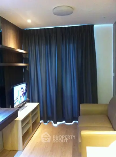 Cozy living room with modern furniture and entertainment setup, perfect for relaxation.