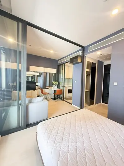 Modern bedroom with glass partition and stylish decor in a contemporary apartment.