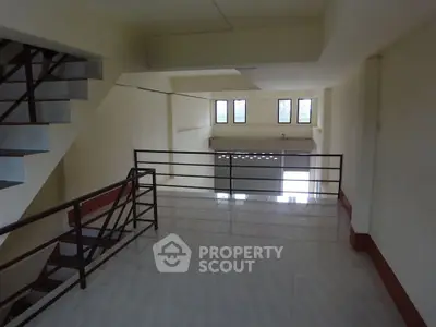Spacious interior with modern staircase and large windows, ideal for versatile use.