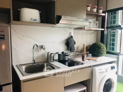 Modern kitchen with sleek appliances and washing machine, featuring a stylish open layout and elegant decor.