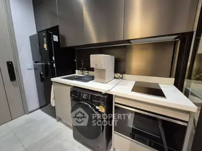 Modern kitchen with sleek appliances and minimalist design, featuring a washing machine and induction cooktop.