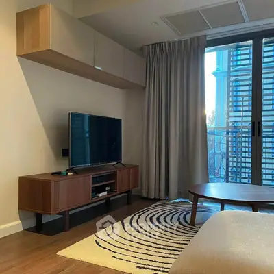 Modern living room with stylish furniture and large window offering natural light.