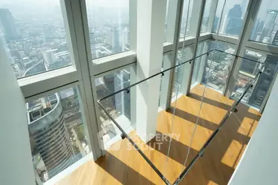 Stunning high-rise apartment with floor-to-ceiling windows offering panoramic city views and sleek wooden flooring.