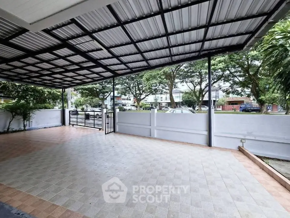 Spacious covered parking area with tiled flooring and garden view