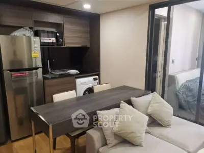 Modern compact kitchen with dining area and washing machine in stylish apartment
