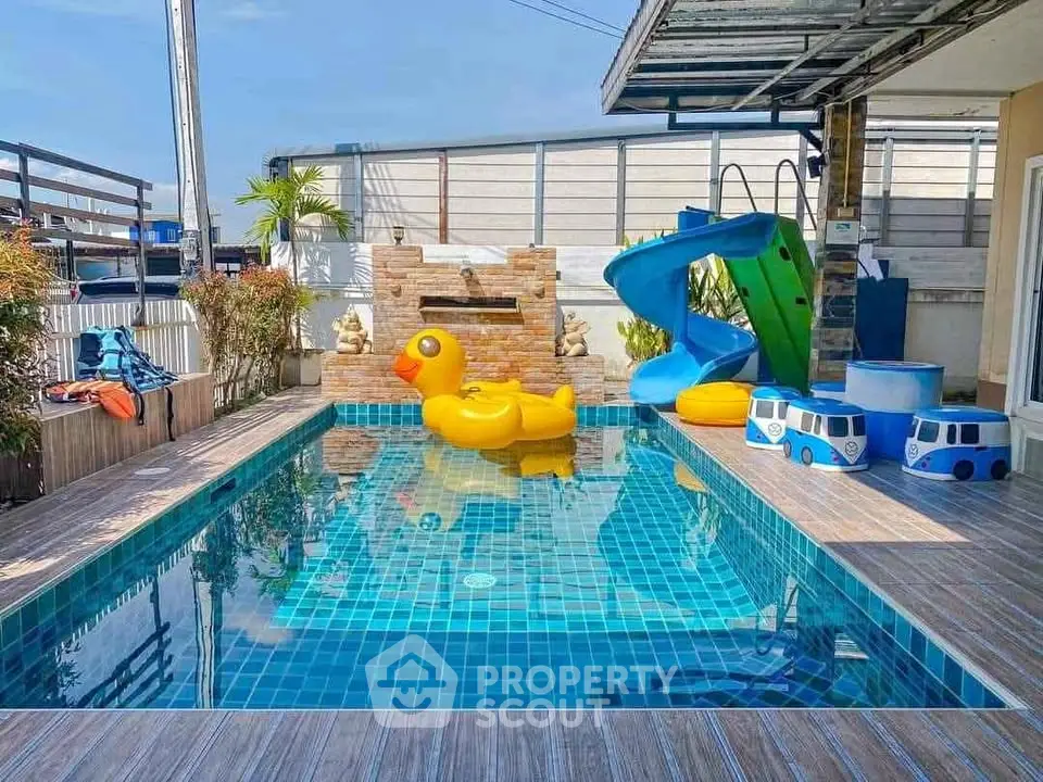 Charming outdoor pool with slide and playful duck float, perfect for family fun and relaxation.